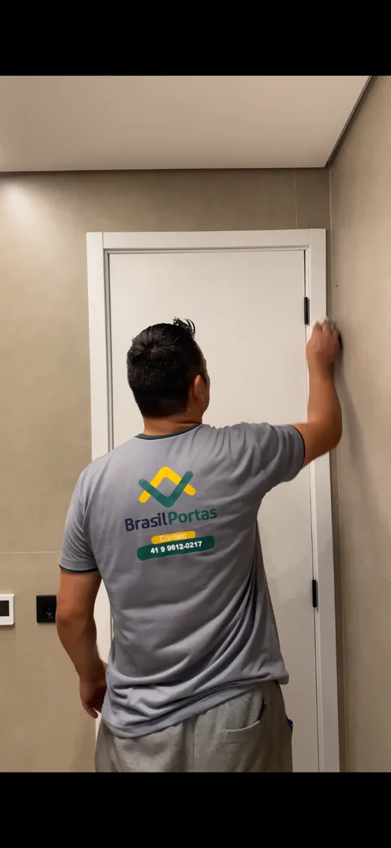 Profissional da Brasil Portas realizando a instalação de uma porta branca